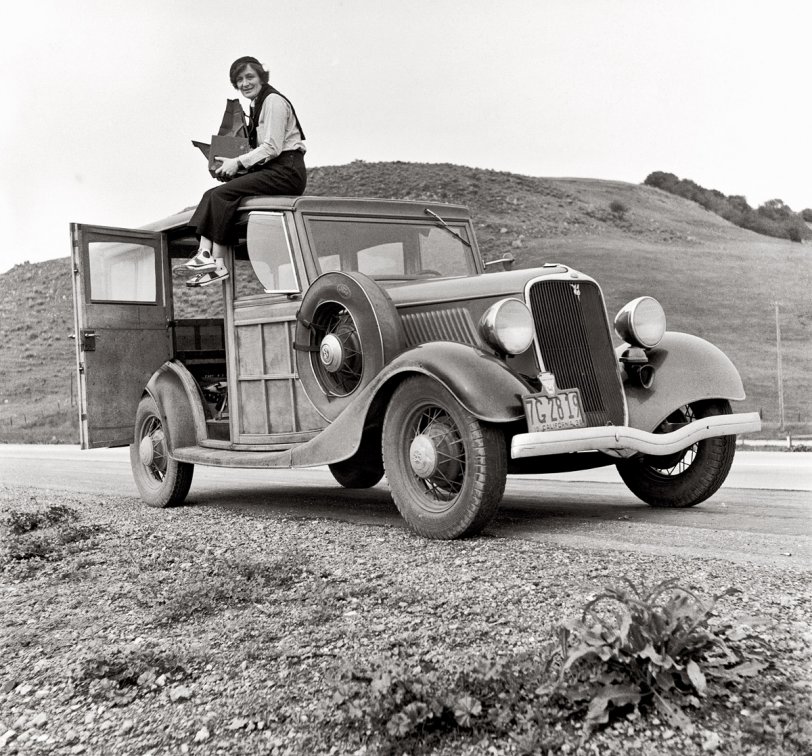 Dorothea Lange, Resettlement Administration photographer, in California atop car with her giant camera. February 1936. View full size.
