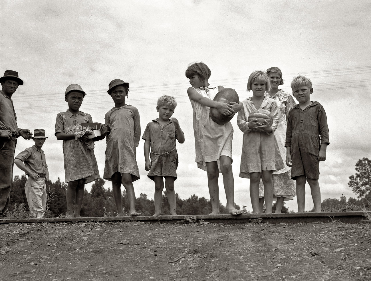 July 1936. Hillhouse, Mississippi. "Sharecroppers' families gathering needs for their Fourth of July celebration, whites and blacks together." View full size. 4x5 nitrate negative by by Dorothea Lange for the Farm Security Administration.