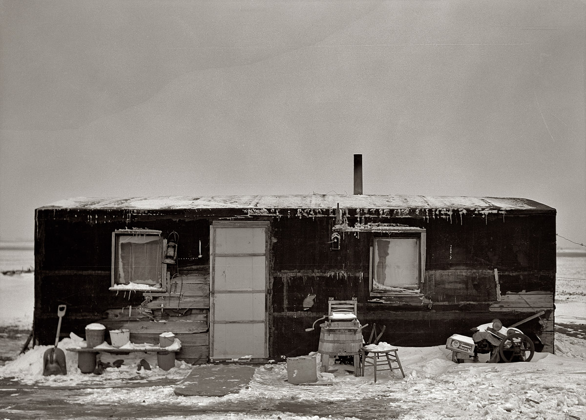 November 1936 near Dickens, Iowa. Three-room shack, the residence of L.H. Nissen, hired man for a tenant farmer. Farm is owned by a loan company. Ten people live in the shack: mother, father, seven children, one grandchild. Medium format negative by Russell Lee, Resettlement Administration. View full size.