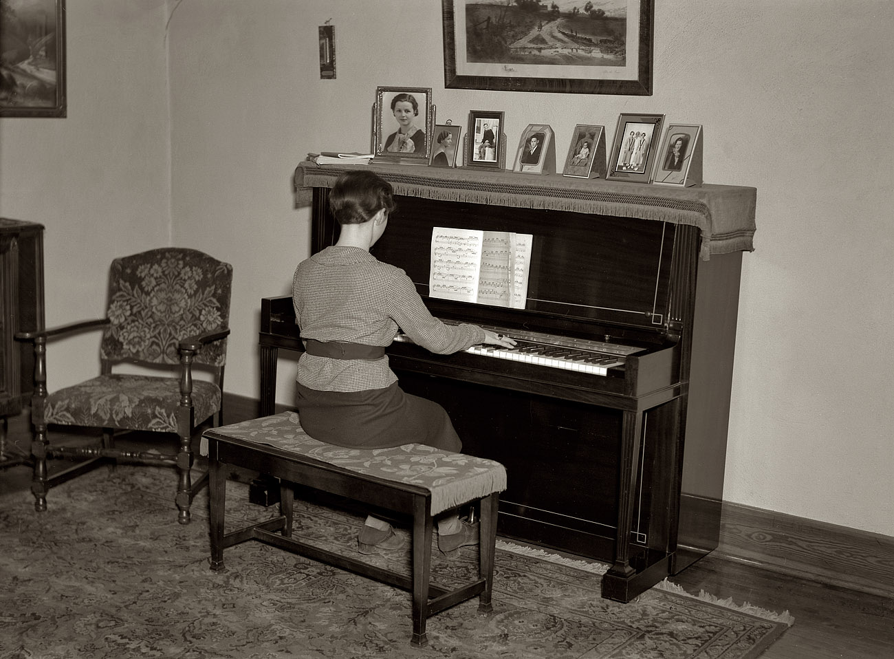 December 1936. "Lois Madsen playing the piano in the home of her father, Harry Madsen, owner-operator of three hundred and sixty acre farm near Dickens, Iowa. (Suggest this as contrast showing difference in opportunity offered children in owner-operated farms and that offered in poorer tenant or hired hand homes)." View full size. Medium format nitrate negative by Russell Lee.