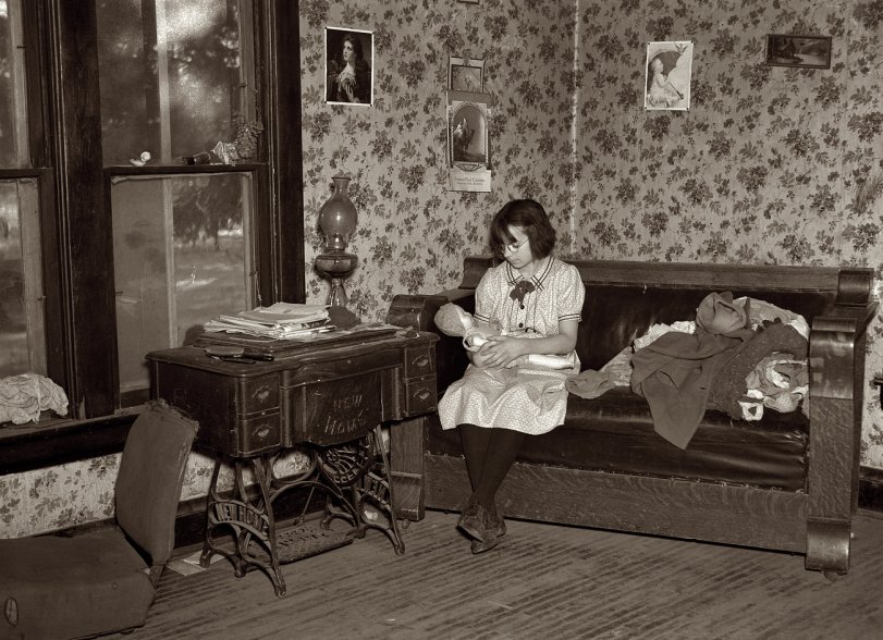 December 1936: "One of Edgar Allen's children playing with doll. The couch and sewing machine are the two most substantial pieces of furniture in the house. The farm is one hundred sixty acres and rented from private party. Near Milford, Iowa." View full size. Medium format nitrate negative by Russell Lee.