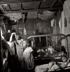 January 1938. "Interior of workers' shack. Porta de Tierra, San Juan, Puerto Rico." Note the drop-in guest. Medium format nitrate negative by Edwin Rosskam for the Farm Security Administration. View full size.