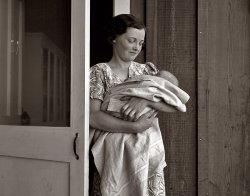 April 1939. Farm Security Administration migrant camp at Westley, California. Migrant mother with sick baby and agricultural workers medical association card. View full size. Photograph by Dorothea Lange.
