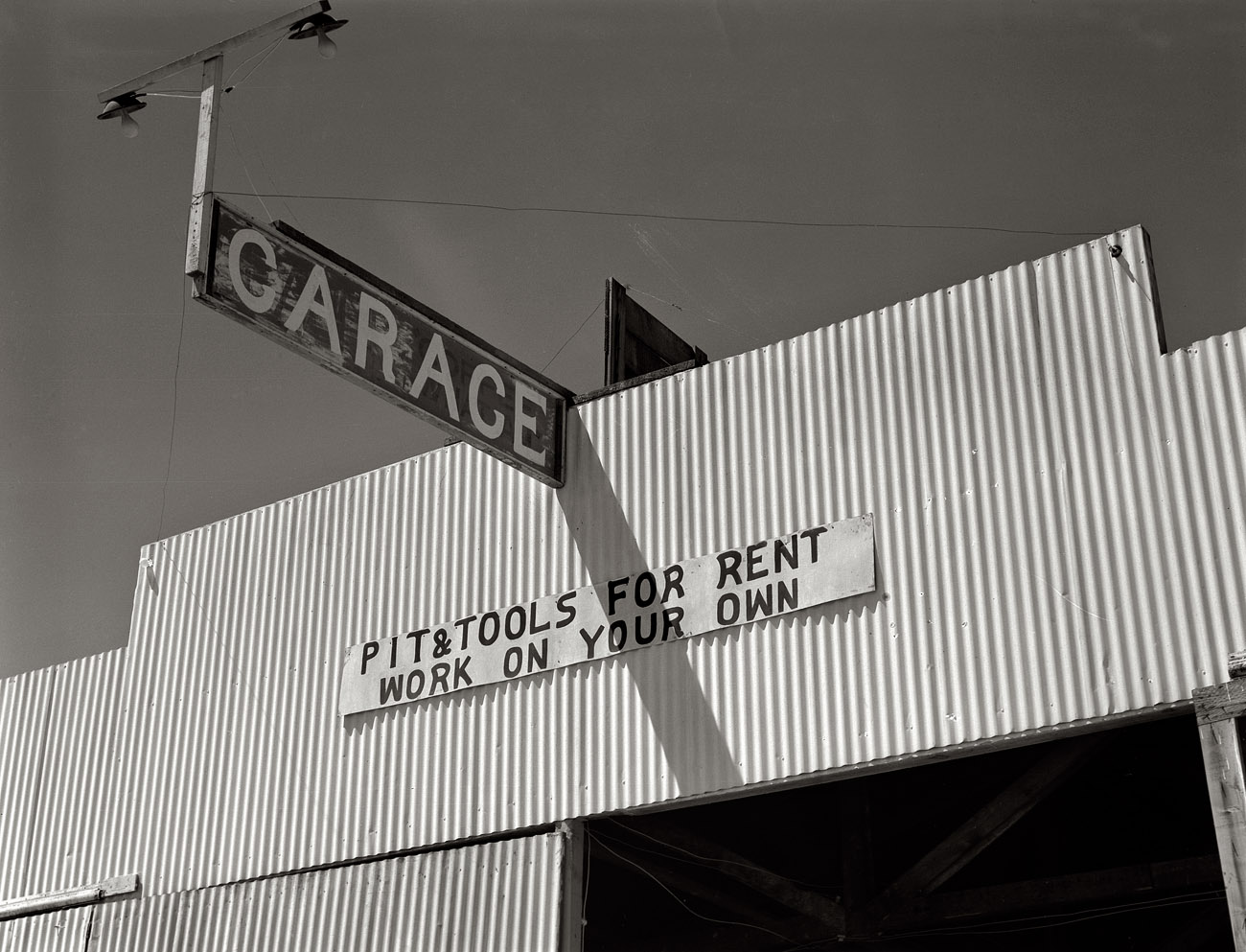 May 1939. Garage on Route 99 in Fresno County, California. View full size.  Medium-format negative by Dorothea Lange, Farm Security Administration.