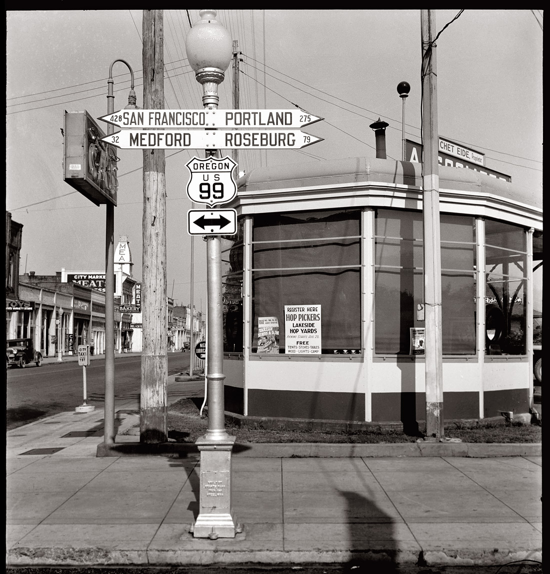 U.S. 99 in Josephine County, Oregon. August 1939. Sign in service station window advertising for hop pickers three weeks before opening season. View full size. Photograph by Dorothea Lange. What city is this? [Answer: Grants Pass]