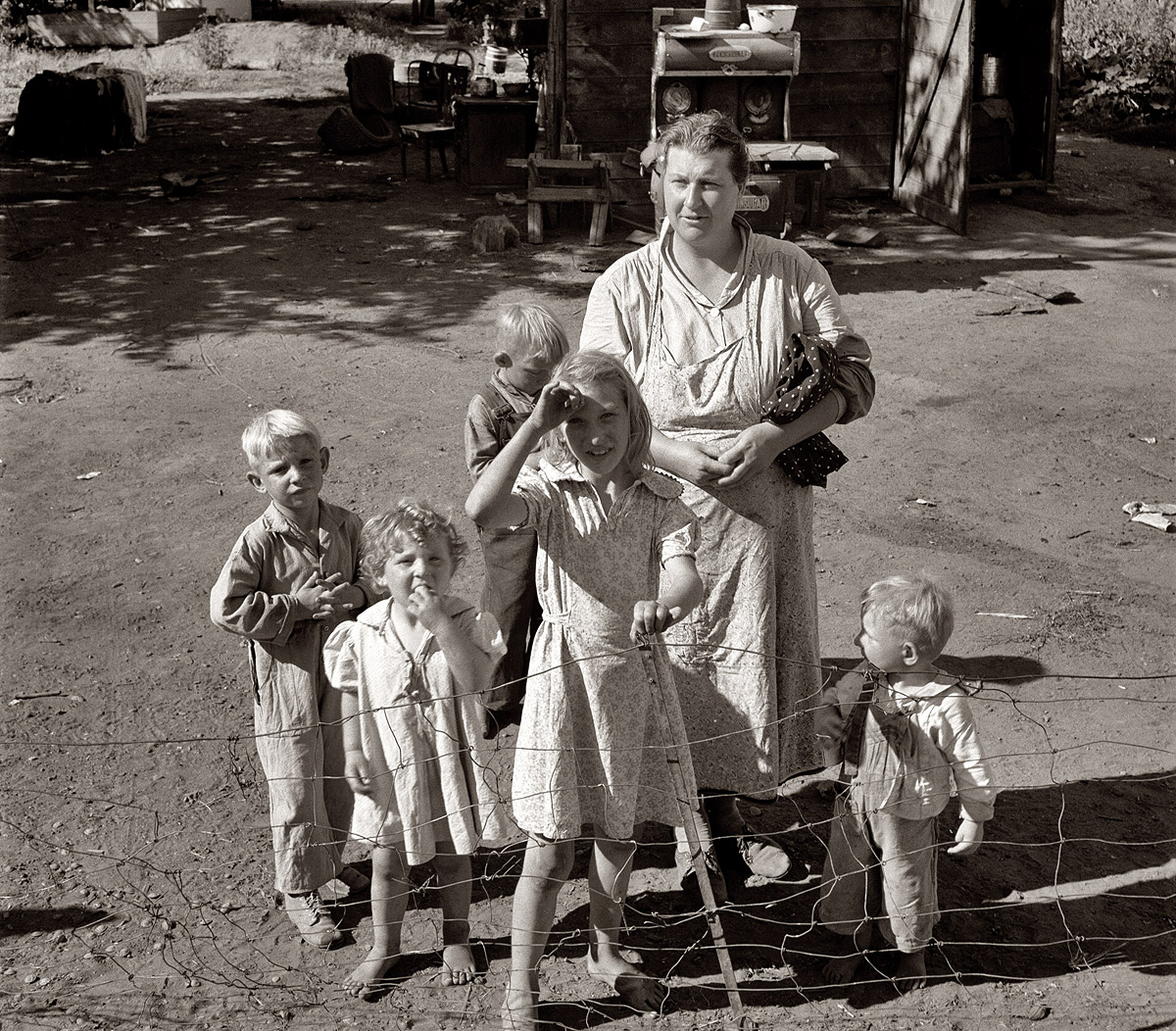 August 1939. Yakima Valley, Washington. Shacktown community, mostly families from Kansas and Missouri. This family has five children, oldest in third grade. Rent $7 per month, no plumbing. Husband earns Work Projects Administration wages, $44 per month. View full size. Photograph by Dorothea Lange.