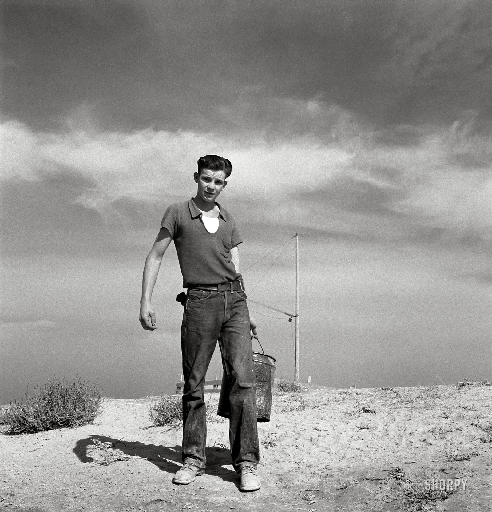 October 1939. "Dazey farm. Seventeen year old boy going to feed the pigs. Homedale district, Malheur County, Oregon." Medium-format nitrate negative by Dorothea Lange for the Farm Security Administration. View full size.