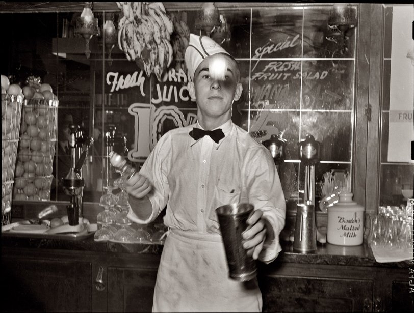 February 1939. Corpus Christi, Texas. "Soda jerker flipping ice cream into malted milk shakes." View full size. Photo by Russell Lee. And make mine a double.
