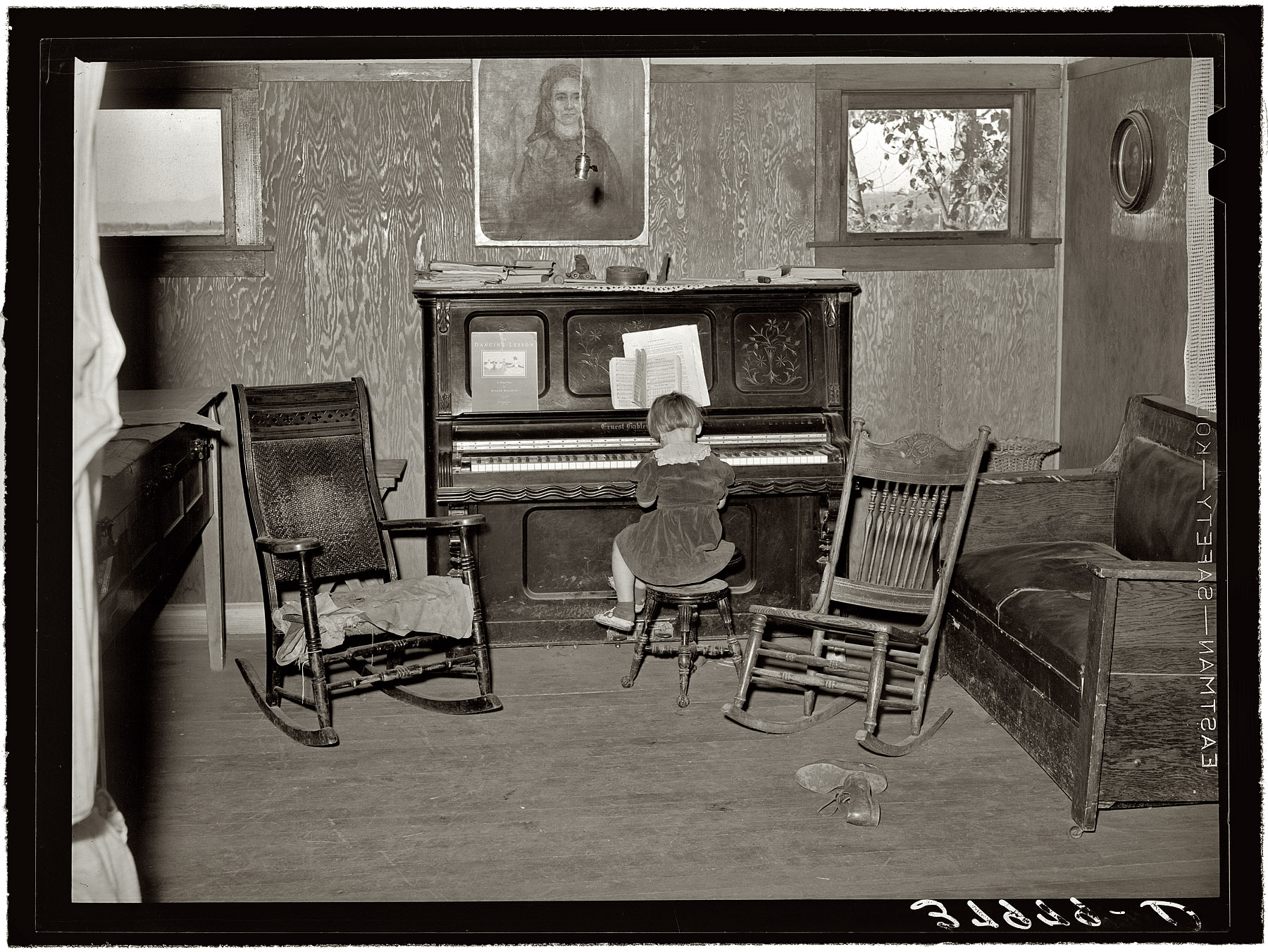 November 1940. "Living room in farm home of John Frost, part owner of 135 acres of semi-marginal land in Tehama County, California. He raises turkeys, hogs and dairy cattle." We met the girl and her dad last week, listening to the radio. Medium format negative by Russell Lee for the FSA. View full size.