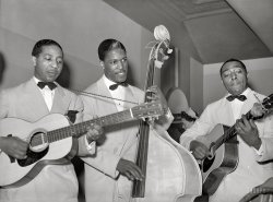 April 1941. "Entertainers at Negro tavern. South Side Chicago." On the left is Lonnie Johnson, noted bluesman and pioneering jazz guitarist. Who are the others? Medium format safety negative by Russell Lee. View full size.