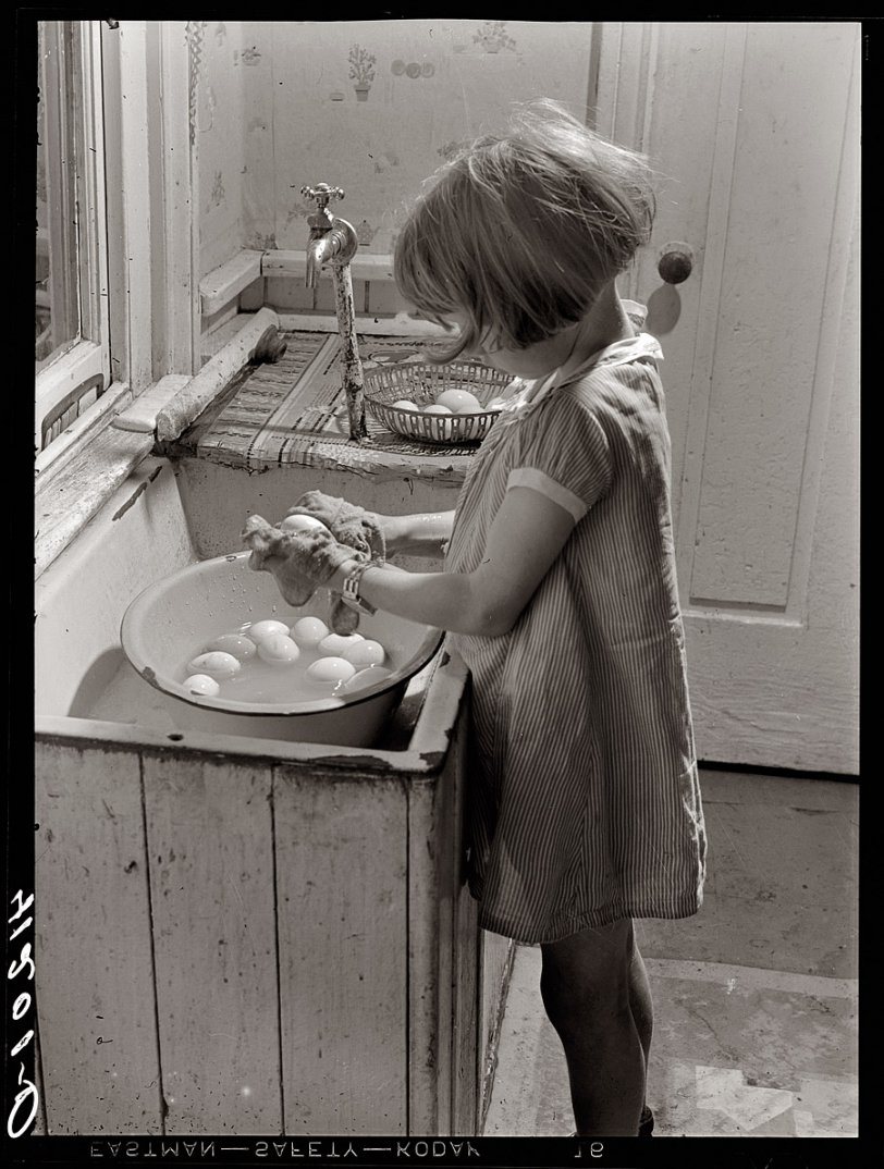August 1940. Little girl at the Reitz farm near Falls Creek, Pennsylvania, washing eggs to be sold at Tri-County Farmers Co-op Market at Du Bois. View full size. 3¼ inch safety negative by Jack Delano, Farm Security Administration.

