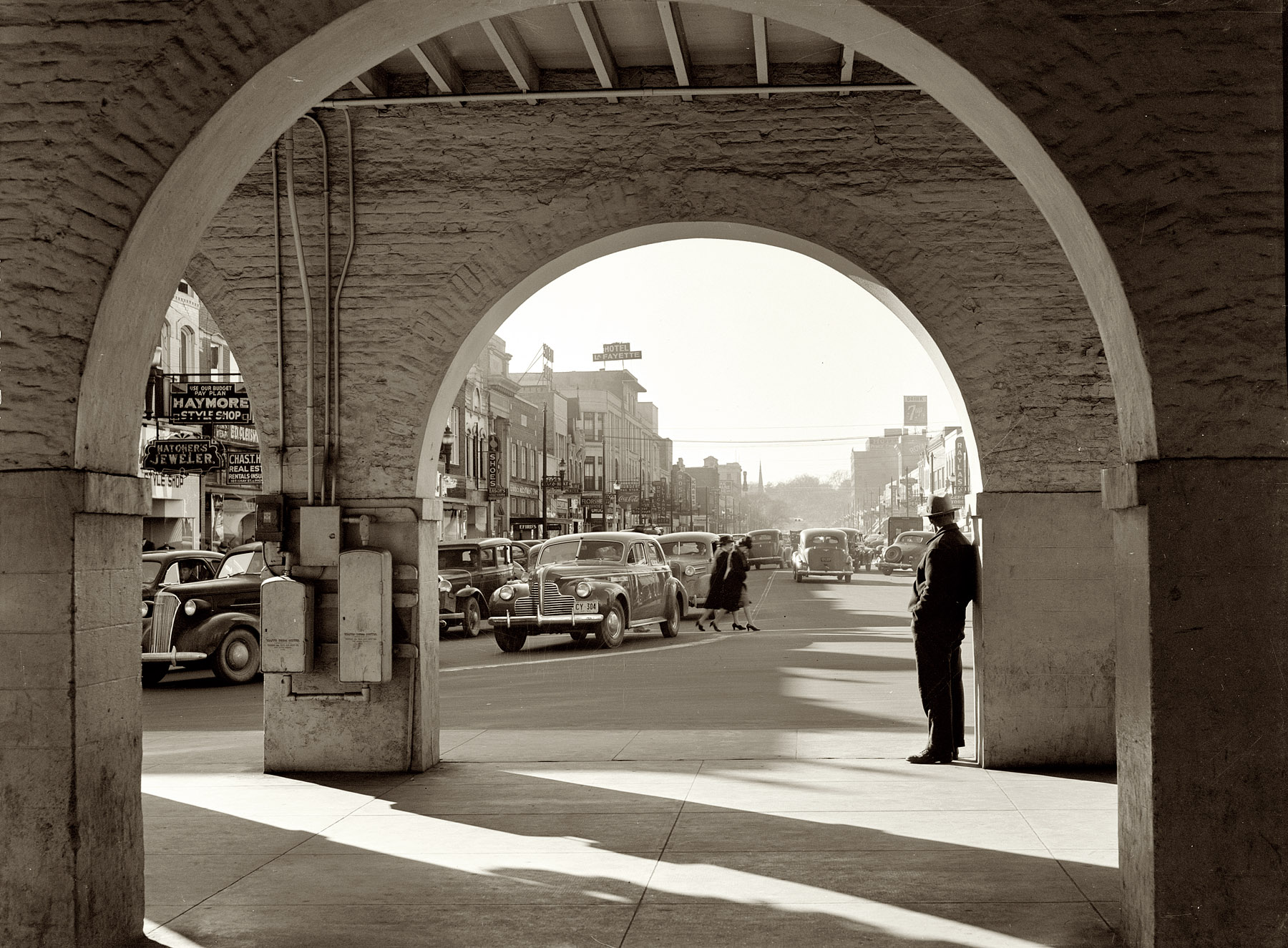 March 1941. Traffic on the main street of Fayetteville, North Carolina, at about 5 o'clock, when the workers start coming out of Fort Bragg. View from the "old marketplace." View full size. Medium-format safety negative by Jack Delano.