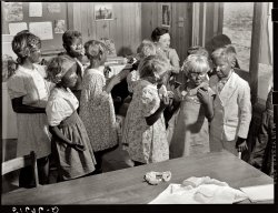 May 1939. "Second and third grade children being made up for their Negro song and dance at May Day-Health Day festivities." Ashwood Plantations, South Carolina. View full size. Photograph by Marion Post Wolcott for the FSA.
My father, my uncle, our neighborsand for that matter the whole mining camp looked like they were dressed in black face when they came out of the mines after a hard day shoveling coal...where they worked side by side with african-americans...and nobody ever gave it a second thought about racial differences.  Everybody was just trying to survive (1940s Alabama).
Ashwood: 1940May 1940: Third and fourth grade children rehearsing for radio comedy, "Amos 'N' Andy: The Early Years."
No way the above picture could happen today without some major controversy.
No way could it happen todayNo way could it happen today at all.
That&#039;s because most peopleThat's because most people nowadays know this is ridiculously wrong.
Amazing how far we&#039;ve comeThis must have been a "fun" time at the school...They were probably in their mid-twenties by the mid-fifties when the many of the race riots, sit-downs, boycotts etc. began in Alabama.   
[Not to mention sit-ins. - Dave]
If you think this isn&#039;t offensive......then I want you to consider what would have happened had a group of black children dressed up in whiteface in 1939,  then sang some traditional "white" songs in mock-patrician accents while lighting cigars with $20 bills.  If it resulted in only their school being burned down, they would have been lucky.
Perfectly acceptable?someone clearly thought this was perfectly acceptable at the time, but the little girl with the mirror?  what might SHE be thinking?  the blonde, blonde hair and peter pan collar!  and that kid in the double breasted suit! i'm not even sure what they're not sure about
Why is it wrong?Is it wrong to dress as an Eskimo to do an Eskimo song and dance? Or dress as Spanish Conquistadors for a play on that subject? Or as white cowboys or Native Americans? Or wear wooden shoes and pigtails for a nice Holland number?
[There's a big difference, these days, between blackface and dressing up as a conquistador. I'll bet most people know what it is. - Dave]
I never really understoodI never really understood why dressing in blackface is supposed to be so hurtful either. Where is the insult?
[Really. Where is the insult? Aside from being mocked by your former owners as shuffling, dimwitted buffoons who speak in moronic dialect, I mean.  - Dave]
Portland, Oregon: 1992When I was in college, a friend mentioned that her church had organized mock Passover ceders [seders?] in which each member of the congregation was assigned a role, with lines to memorize, etc. She was surprised to discover that somebody she knew sincerely celebrated the holiday, and was worried that she had committed a faux pas along the lines of dressing in blackface.
In practice, I just found it funny.
Dressing as a member of another culture, even in a stereotyped manner, is not inherently offensive, though it can become offensive if it derives from a history of degrading depictions. Those who have never seen footage of old blackface performances may not be aware of what they entailed. I suggest renting the Al Jolson film "Wonder Bar," which ends with a jaw-dropping blackface routine set in Negro heaven. The movie also includes memorable pre-Hays-Code material about homosexuality and suicide.
Junior HighI remember acting in the 7th grade play in Jr. High School in Ohio in 1966 as the only black character in the play. I portrayed the character in blackface and stole the show. Of course in 1966, 2 years after the Civil Rights Act, the correct term was Negro.  
MinstrelsyIn 1948 my high school had a minstrel show.  Today I marvel at the Chicago Public Schools' insensitivity  in allowing this.  To top it off, our school didn't have an auditorium, so we had the show in a heavily black school.  We were a bit uneasy.
Amos &amp; Andy"I never understood why, in a a radio broadcast,, the performers had to be in blackface make-up."
If you're talking about Amos &amp; Andy they didn't. Freeman Gosden and Charles Correll, didn't wear blackface for their broadcasts although they did "black up" (as was the common term for applying blackface) for publicity photos - wear they were frequently seen at the microphone - and for their rather infamous feature movie "Check and Double Check" which was the highest grossing RKO picture until "King Kong." When "Amos &amp; Andy" moved to TV, the entire cast was made up of African-Americans.
Alternate activity suggestionsFor the people who imagine that dressing up in blackface is just imitating an ethnic group, consider that the whole blackface minstrel thing was invented by white people as a representation that they wished were true, because it made black people easy to dismiss.
If these people were genuinely interested in imitating black people where's their "Fredrick Douglas oratory contest" or their "Duke Ellington piano recital"?
Well, I guess that wouldn't be as educational as smearing black paint on your their faces would it?
Ashwood 1939I never understood why, in a  a  radio broadcast,, the performers had to be in blackface make-up.
Ashwood KidsMuch to these kids' credit, none of them appears to be having a very good time. The way many of the girls are holding their arms out would indicate that they are desperately trying to avoid getting any of whatever that stuff is all over their dresses. This sort of thing was by no means relegated to the south. Click here to view a still of Mickey Rooney and Judy Garland in a scene from the 1941 film "Babes On Broadway."
Some temporal perspective, please.    Many of the commentaries concerning the photograph are no more than guilt swathed in politically correct speech.  What is the point of such nonsense?  The photograph stands for itself.  A fraction-of-a-second glimpse of America, in that time and that place. No other.  Any attempt to impute guilt, shame or right-or-wrong is doomed to failure. It amounts to nothing more than whining and sniveling by first-world people with electricity, computers and full bellies.  Knock it off.
     I propose we work to identify the, "sense," of this and other photographs that this glorious Shorpy venue offers.  The subjects. THEIR thoughts and actions.  What was the photographer trying to show show and say?  And look toward the technical details of structure, identity, light, health, dress, and many thousands of details that are lost when the, "I'm Politically Correct," lot start in on a subject.  They belong on Craigslist Rants and Raves with those other such people who have reduced their lives to bumper-sticker philosophies.
     I am very grateful that this photograph exists.  Without it, we would all be a poorer people.  These are our ancestors, and like us, they are found in a place and time like no other.  This photograph was taken 69 years ago.  I am fairly certain that 69 years in the future, many of OUR activities will be viewed as those of barbarians.
Thank you,
John D. Rockhill
Tempe, Arizona 
Late to the game..I know I'm late to the game with my comment, but...little children are not prejudiced, but this is a prefect example of young learning from their elders!  Very sad!  Shame on John for not believing this can be hurtful!  I also love the pictures and take the offensive with the beautiful, but I believe it was wrong.
History, RevisitedThe greatest thing about photography is that the perspective of viewers keeps changing as the years pass.
(The Gallery, Education, Schools, Kids, M.P. Wolcott)