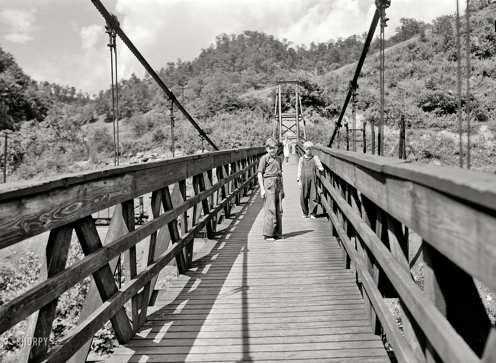 July 1940. Hazard, Kentucky. "Miners' children crossing swinging bridge from their homes into town." Photo by Marion Post Wolcott. View full size.