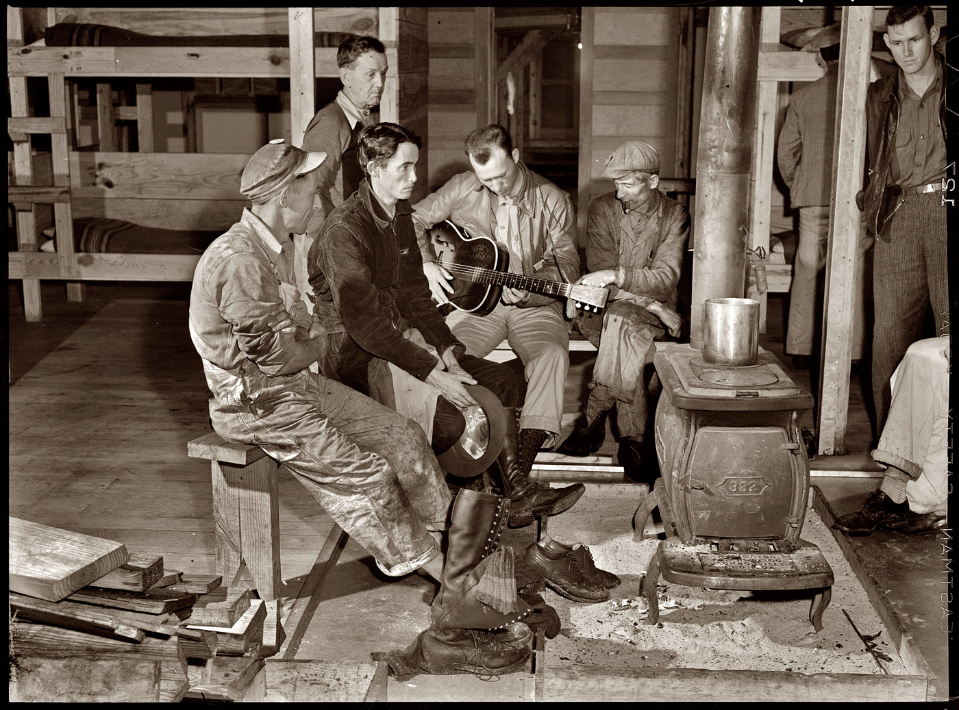 December 1940. Construction workers gathered around the bunkhouse stove in the new craftsmen's barracks at Camp Blanding, Florida. View full size.
 Medium-format safety negative by Marion Post Wolcott for the FSA.