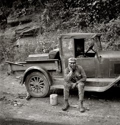 September 1938. Capels, West Virginia. "Miner waiting for ride home. Each miner pays twenty-five cents a week to owner of car." Medium format negative by Marion Post Wolcott for the Farm Security Administration. View full size.