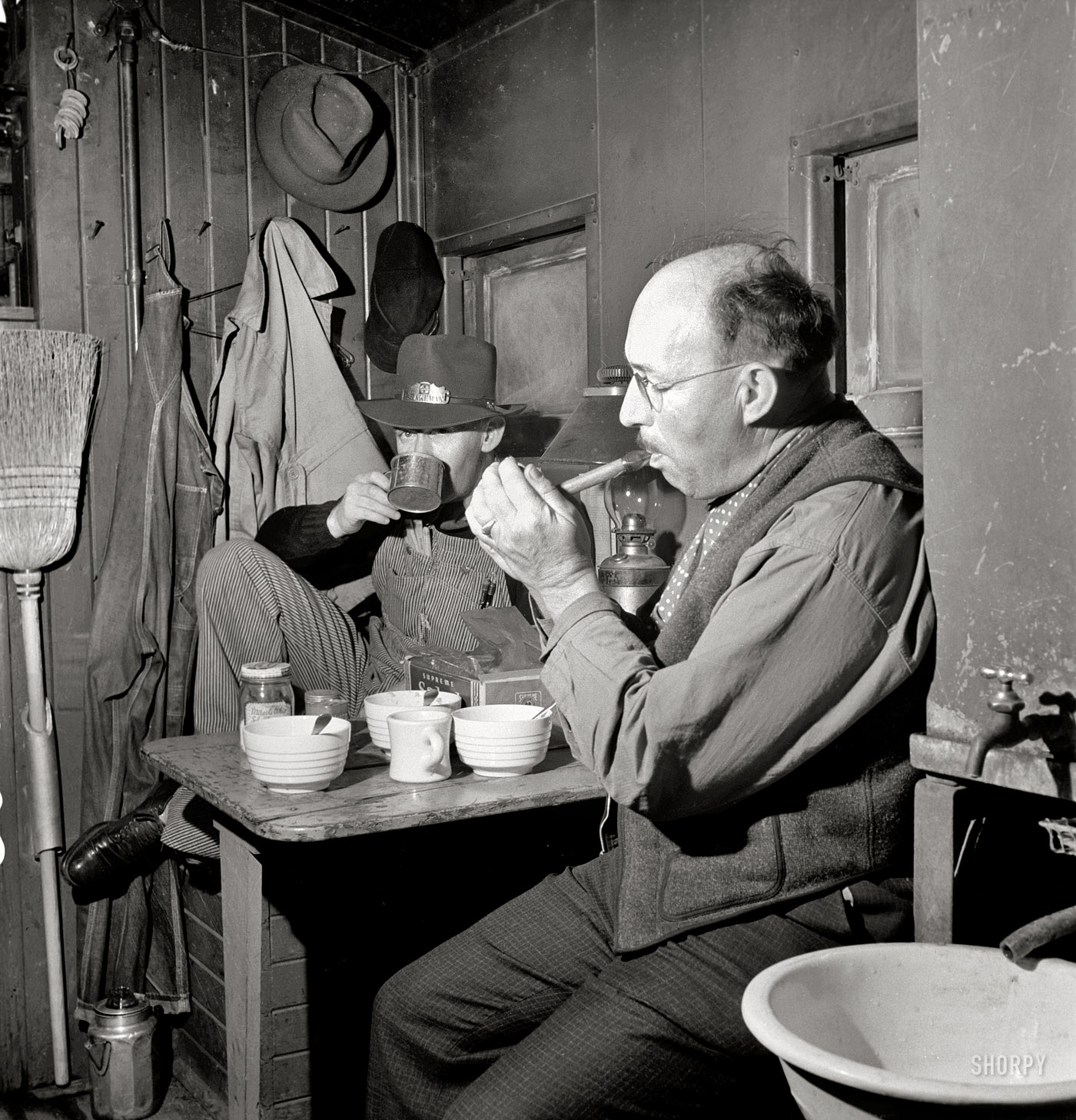 March 1943. "Conductor James M. Johnson and brakeman Jack Torbet having lunch in the caboose on the Atchison, Topeka and Santa Fe Railroad between Waynoka, Oklahoma, and Canadian, Texas." Medium-format nitrate negative by Jack Delano for the Office of War Information. View full size.