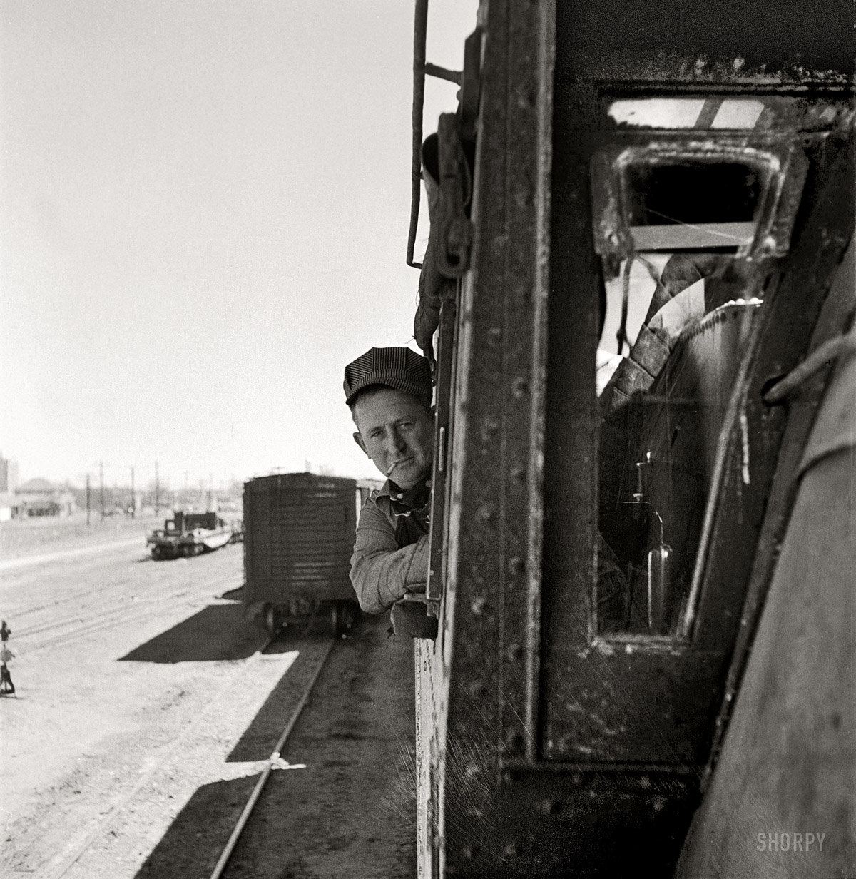 March 1943. "Clovis, New Mexico. D.L. Clark, engineer, ready to start his locomotive out of the Atchison, Topeka and Santa Fe Railroad yard." Medium-format negative by Jack Delano, Office of War Information. View full size.