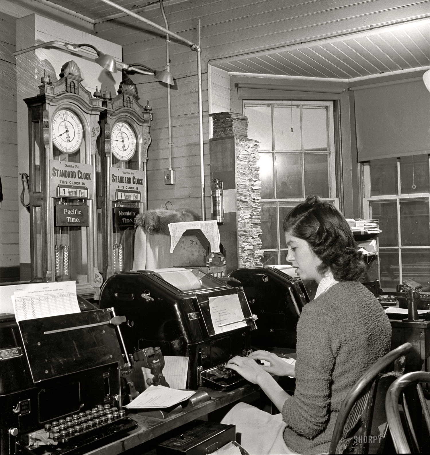 March 1943. "Seligman, Arizona. Teletype operator in the telegraph office of the Atchison, Topeka, and Santa Fe Railroad. The time here changes from Mountain to Pacific time." Medium-format safety negative by Jack Delano. View full size.