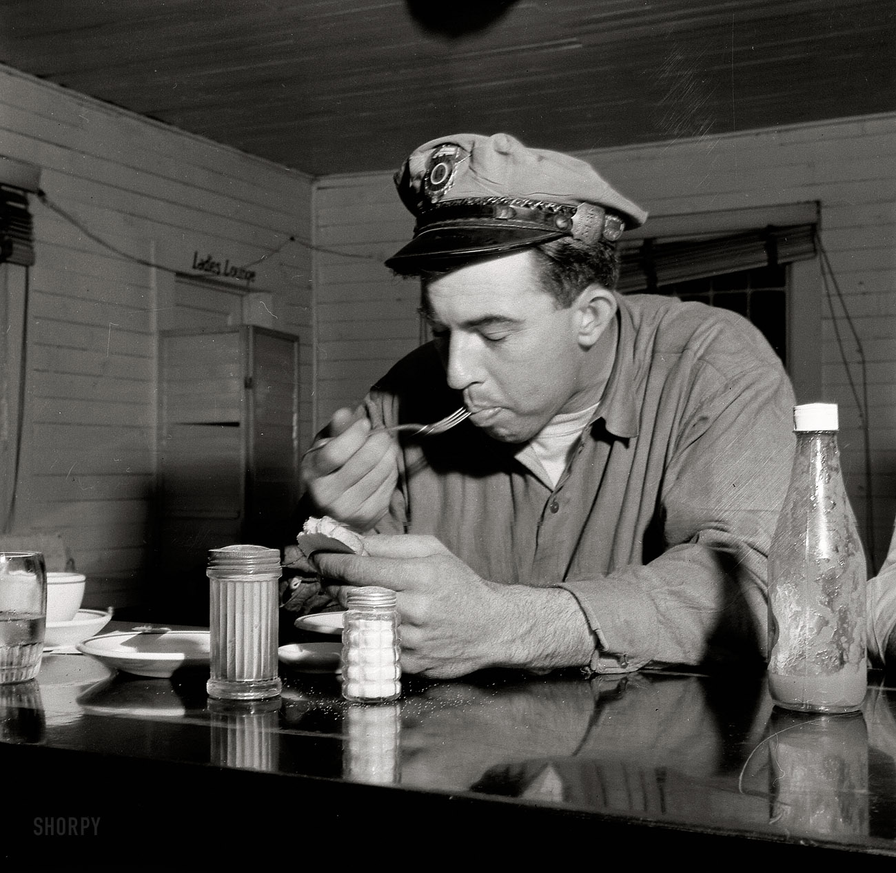 March 1943. "Pearlington, Mississippi (vicinity). Truck driver eating at a trucker's stop along U.S. Highway 90." Hey buddy, pass the salt? Medium-format nitrate negative by John Vachon for the Office of War Information. View full size.