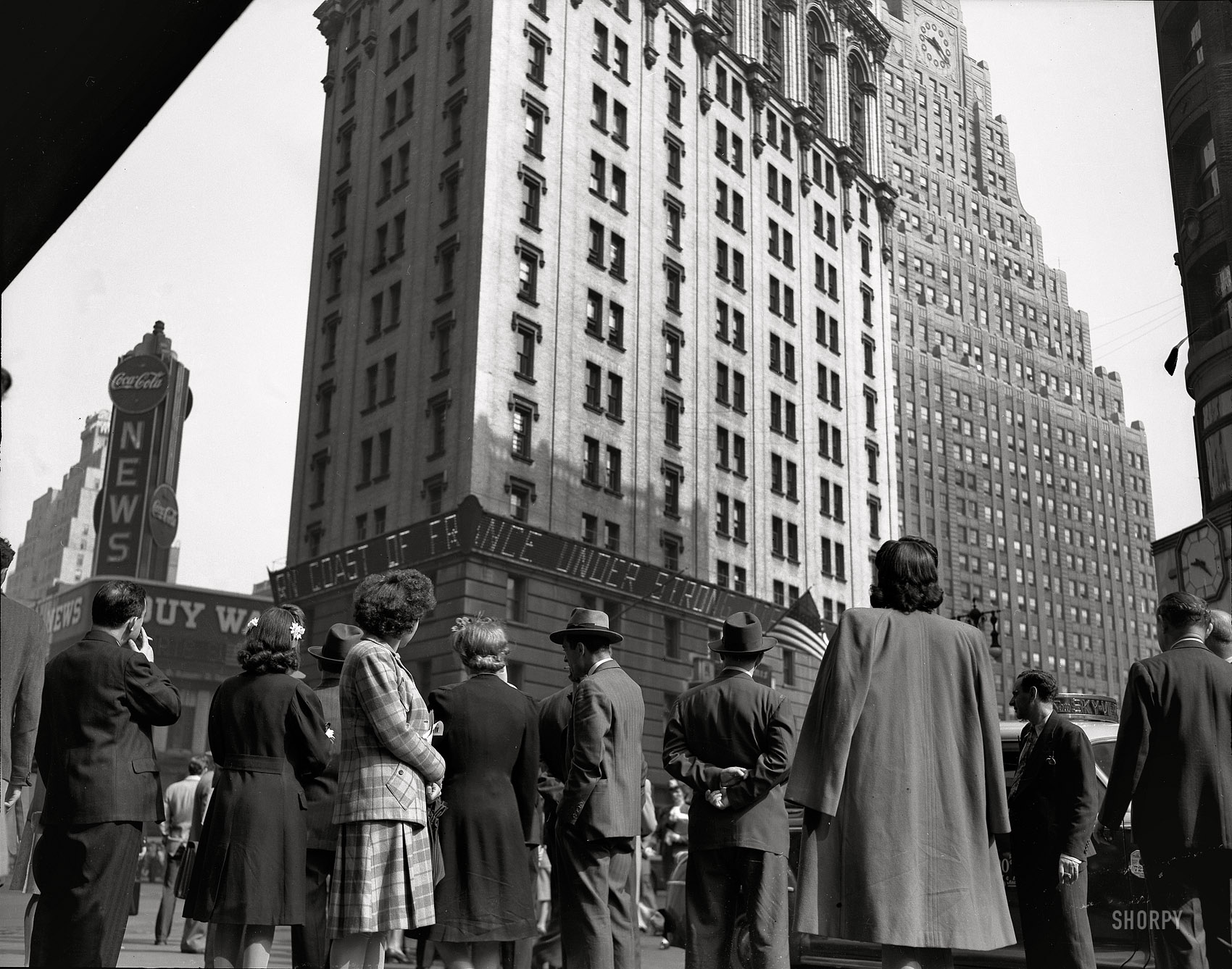 New York, June 6, 1944. ALLIED ARMIES LAND ON COAST OF FRANCE. GREAT INVASION OF CONTINENT BEGINS. "D-Day. Crowd watching the news line on the New York Times building at Times Square." Photo by Howard Hollem or Edward Meyer for the Office of War Information. View full size.