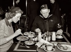 December 1943. Washington, D.C. "Hugh and Lynn Massman eating lunch at a cafeteria after a day of sightseeing. Their eight-week-old son is being taken care of at the United Nations service center nursery." Medium-format safety negative by Esther Bubley for the Office of War Information. View full size.