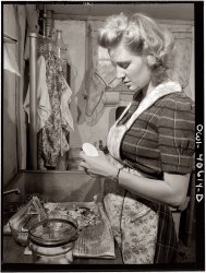 December 1943. "Lynn Massman, wife of a second-class petty officer who is studying in Washington, preparing dinner."  View full size. Photograph by Esther Bubley for the Office of War Information.