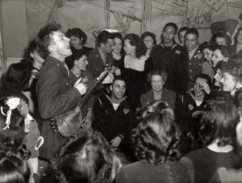 February 1944. The folk singer Pete Seeger entertaining Eleanor Roosevelt, honored guest at a Valentine's Day party to mark the opening of the United Federal Labor Canteen in Washington. View full size. Medium-format safety negative by Joseph Horne for the Office of War Information.
