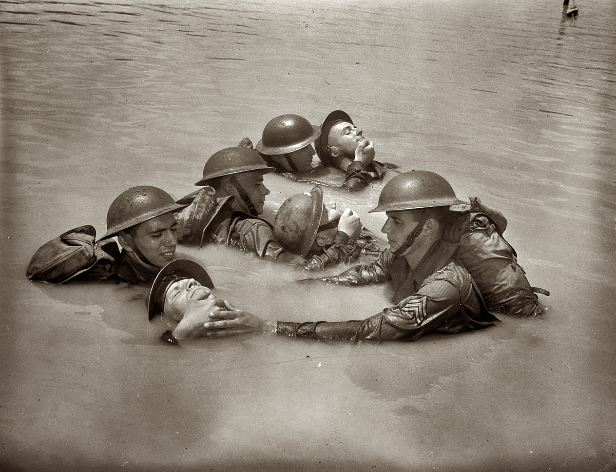 "Soldiers in full field equipment learning the 'chinpull' method of saving men from drowning" circa 1942. American Red Cross archives. View full size.