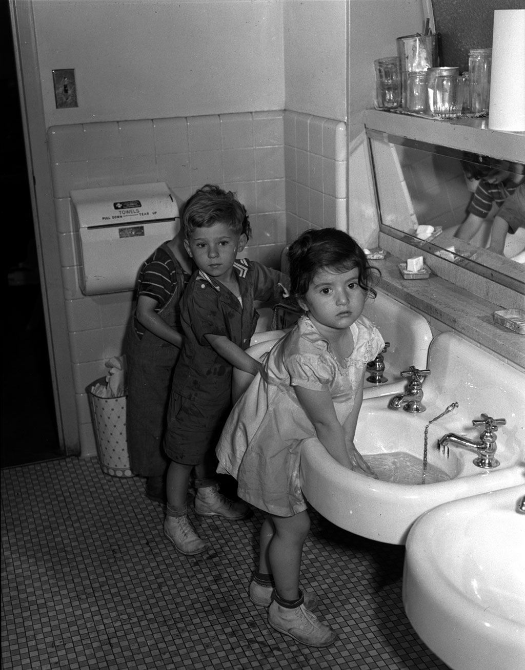 Children wash before lunch at the nursery school at the Red Hook housing project community center in Brooklyn, New York. Photograph by Arthur Rothstein, June 1942. View full size.