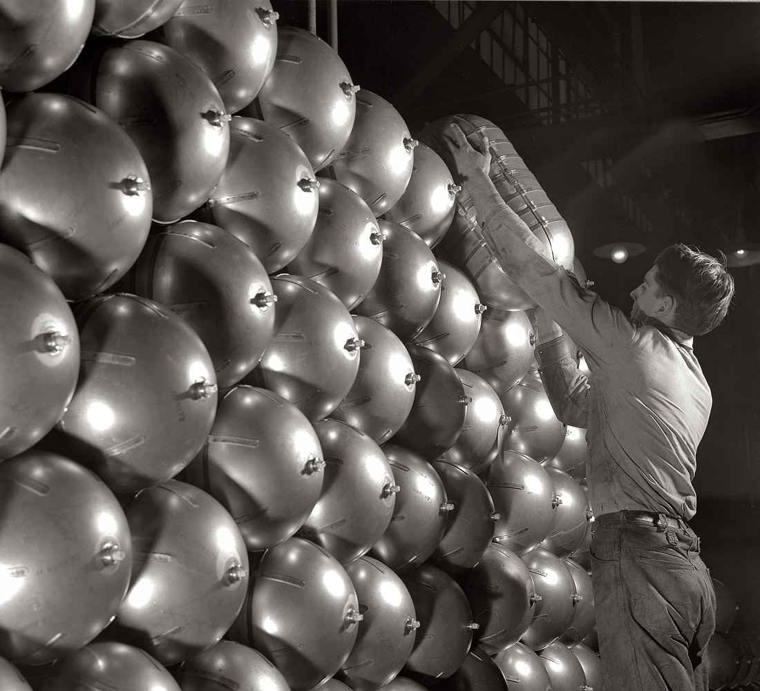 February 1942. Firestone factory at Akron, Ohio. War conversion of beverage containers. An oxygen cylinder for high altitude flying, manufactured by the metal division of a large Eastern rubber factory, placed on a huge stack ready for shipment to the Army. View full size. 5x7 nitrate negative by Alfred Palmer.