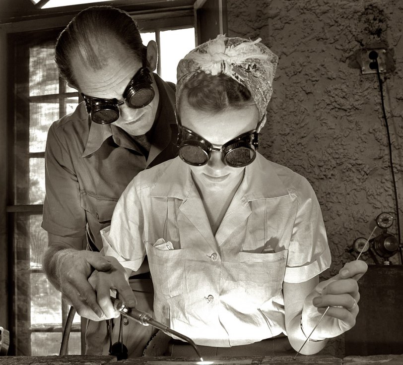 April 1942. DeLand, Florida, machine shop pool. "Aircraft construction class. Clyde Williams, instructor in the Daytona Beach Vocational School, guides the hands of Marie Myers in the first steps of becoming an aircraft welder. Marie was a high school student taking a business course, when she gave it up for defense training entitling her to a high school diploma. She has two brothers in the Army." View full size. 4x5 negative by Howard Hollem, Office of War Information.
