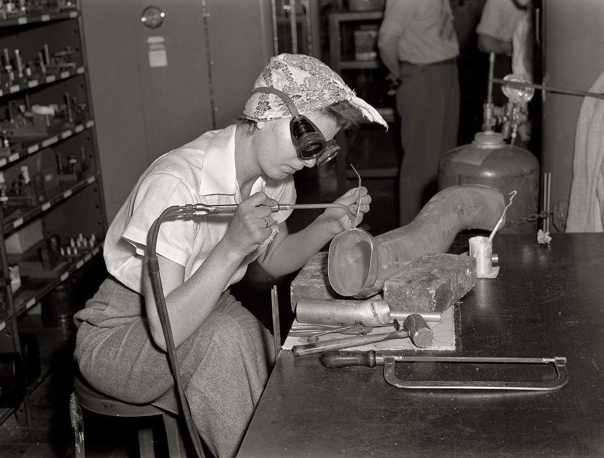 July 1942. Ford plant at Willow Run, Michigan. "Steady of eye and hand, women workers at the great Willow Run bomber plant are among those throughout the country who are relieving serious shortages of skilled workers by doing such semi-skilled jobs as the one here. She's welding parts of the cooling system direct to the supercharger." View full size. Medium format negative by Ann Rosener.
