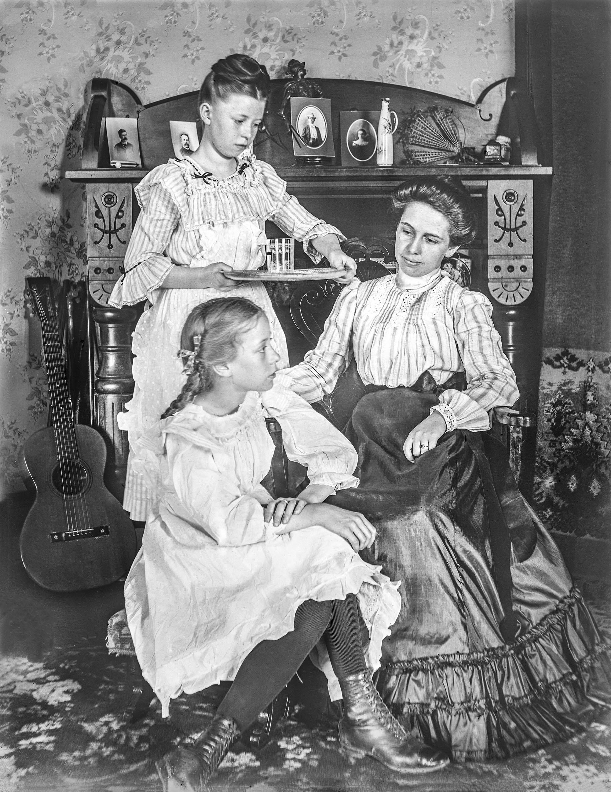 An unknown mother and her daughters sit for a portrait, circa 1910 or earlier in Pawnee City, Nebraska. From the original 4x5 glass negative.