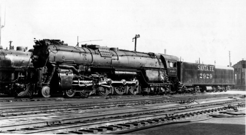 The last of AT&amp;SF's 4-8-4's, #2929, sits on the ready track at 1st Street engine terminal, Los Angeles, in August of 1949, being readied for a trip east later in the day.  She'll run to La Junta, Colorado for certain, or perhaps onward to Kansas City, 1776 miles away. The latter run was the longest ever regularly-scheduled run by a single steam locomotive, and won Santa Fe's 4-8-4's the title of "Distance Champions" for the duration of their careers. View full size.
