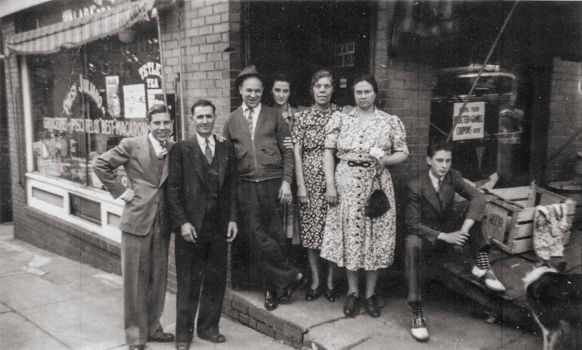A meeting of the Anecelles and the Lombardis at the Lombardi Import Market in Syracuse, New York. Circa 1940. View full size.