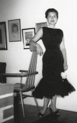 My mother was a fashionista before they had the word fashionista. She was also a dedicated sew and sew. As a consequence more than half of the photos in our family album are documentation of the clothes she designed and sewed. I think this may be the dress she made for my father’s mother’s funeral in 1959 because it is black, but I am not sure. Another theory is that she made it for the trip to Cincinnati that RCA sent my father on. That week-or-two trip included wives. In any event, it looks a heck of a lot like Barbie’s “Solo in the Spotlight” even down to the fake flower by her left knee.
In this photo (taken by my father) she is leaning on the top of the Paul McCobb "captain's chair" (previously seen here) in front of three drawings she did. The far left is a portrait of three-year-old me. The center picture is a tree. And behind her shoulder is a portrait of my father. The bricks in the foreground are part of the free standing fireplace that was a central feature of this mid-century modern Levittown home.
(ShorpyBlog, Member Gallery)