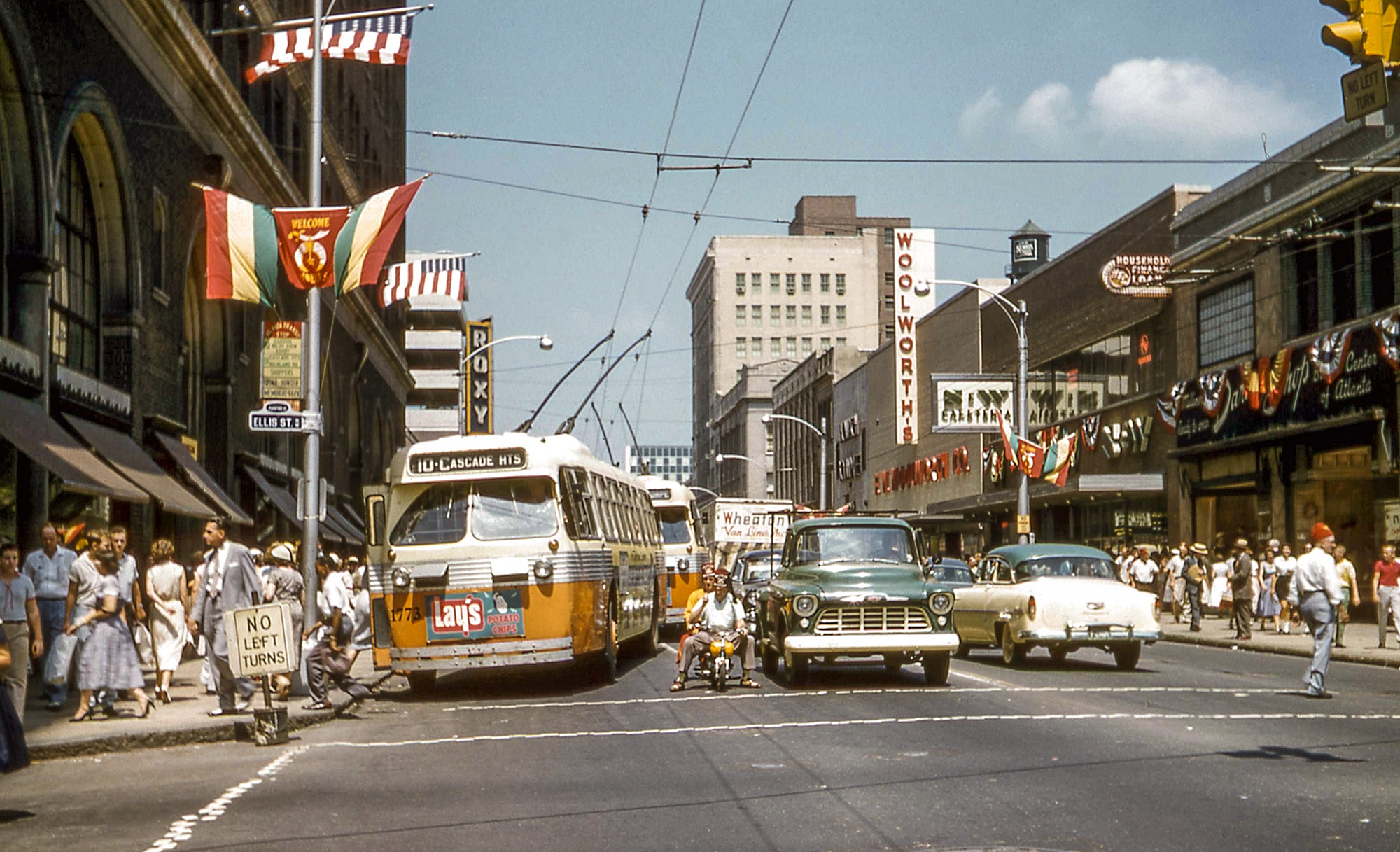 We are looking north on Peachtree Street in downtown Atlanta on August 30, 1957. On the left is one of Atlanta's two principal department  stores, Davidson's; also, the Roxy Theater that ran second runs. I remember seeing "Grapes of Wrath" there. The clowns on the tiny motorcycle are part of the annual Shriners' convention. Kodachrome slide by me, William D. Volkmer. View full size.