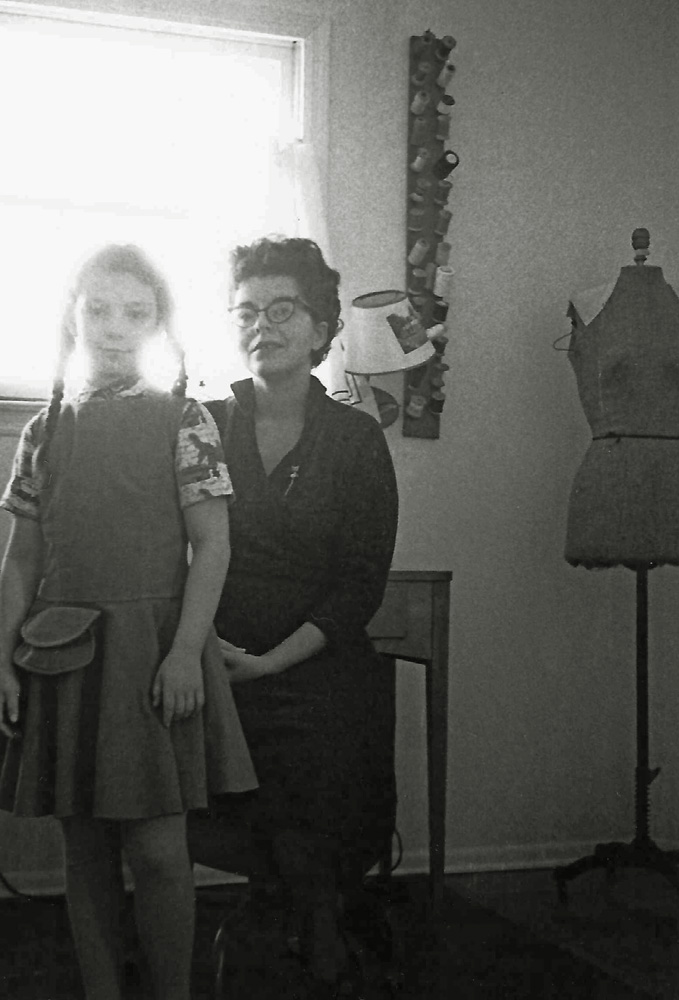 My mother’s sister Harriet came to visit our new house in Princeton, New Jersey and took a whole roll of 35mm film featuring our family and the new rooms we had. In this portrait of the sewing room my mother placed me in front of her to show off the jumper and blouse she had designed and made. The strange looking pocket on it was apparently a concession to my taste. I liked having pockets, so she knew that if she designed outfits with big pockets I would wear them. The jumper was tan velveteen and it looks like there were dinosaurs on the shirt. On her lapel is a gold-tone scatter pin that I loved. I do not remember if it was a cat or mouse, but it had a jointed tail that hung down and would swing.
