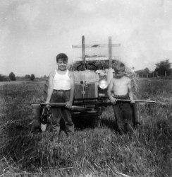 My Dad's cousins at our farm in St. Martin, Ohio (just outside Cincinnati). This was the big summer getaway place for the family after my grandfather bought it in the late '30s.  Every boy should learn his way around a shotgun . . . and a tractor! View full size.
Ford N-seriesNifty tractor! Looks like an N-series. We have an old 8N that my grandfather bought in '48 and it still runs!
(ShorpyBlog, Member Gallery, Kids)