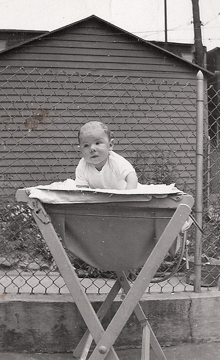 My mother worked for Zepp photo labs through WWII. She had several box cameras, took and developed lots of pictures.  I was the new kid on the block.  Note the elaborate setting, concrete yard underneath.  I believe I was dropped on my head a lot as an infant.  (OK, so do you see anyone nearby to keep me from rolling off?  I didn't think so!)  This was our back yard, 719 N. Luzerne Avenue between E. Monument and E. Madison.  I was born in April...so can't be too long after that when the shot was taken.  (Er, sorry, I just don't even remember it, but I was there.) View full size.