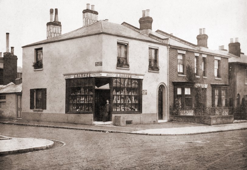 My great-grandfather's shop in Southampton UK, with  my grandfather in the doorway.  Grandfather was born in 1890, he doesn't look older than 15 here, so I guess the picture was taken around 1905 or slightly before.  I remember the shop in the 1950's when grandfather and his two spinster sisters had taken over and it looks just like it did then. View full size.
