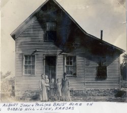 The Baus/Weber home in Linn, KS. Circa 1902. This is my Great Grandmother Paulina Baus/Weber with four of her thirteen children. The caption written on the scrapbook under the picture says 'Gobbie Hill.' Linn, KS.
The family left Kansas around 1904 for a new life in the booming town of Los Angeles. We Great Grandchildren also born in Los Angeles always called them 'Gross Grandpa and Grandma;' gross meaning great in German. Great Grandfather was born the first day they arrived in New York from Germany, thus the family legend is that he was made in German but produced in America. No family member today knows or can find out where Gobbie Hill might have been. View full size.
(ShorpyBlog, Member Gallery)