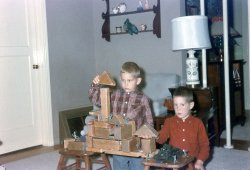 My brother and me in our San Mateo, California living room, constructing a masterpiece of military fortification. Notice the tin soldiers on the parapets, the cars &amp; trucks hidden in the crevices, and the tank parked below. View full size.
(ShorpyBlog, Member Gallery)
