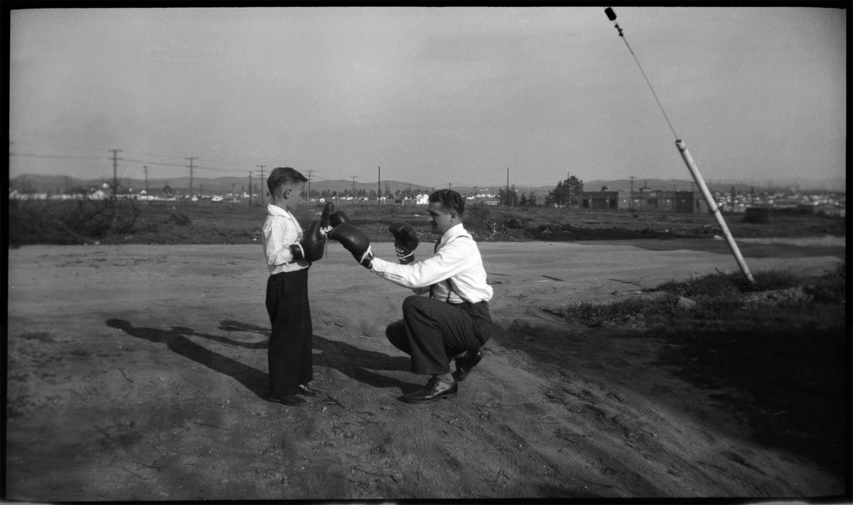 This is my great grandfather and my grandpa as a child practicing their boxing skills. I think this is sometime after WWII. I love the wide-screen film format. Scanned from an 11 X 7.5 CM negative. It doesn't say what brand. View full size.