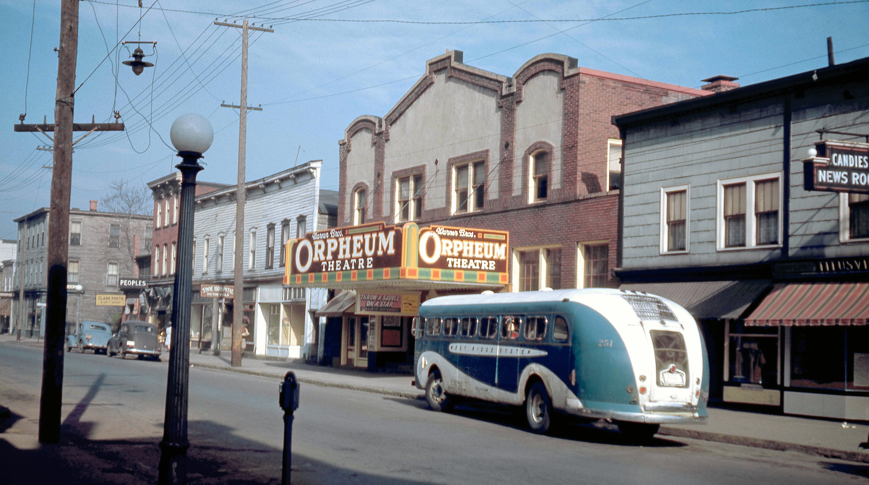 Titusville, Pennsylvania, 1946. West Central Avenue as seen from the Archer Camera Shop, showing a newsstand, bus stop and the Orpheum Theatre. The movie playing is "Throw a Saddle on a Star," which is how I was able to date this Kodachrome slide taken by my grandfather from his camera shop that he and my grandmother owned and operated from 1929 to 1961. View full size.