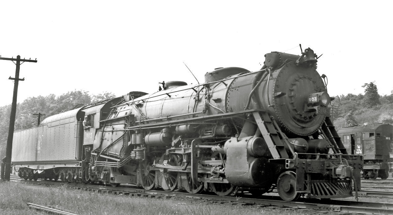 Another from the large-format steam library.  Central Railroad of New Jersey 903 (ALCO 1923), photographed near the roundhouse at Bethlehem PA in 1948.  This Mikado type sports dual air reservoir tanks on the pilot and an oversized Wooten firebox needed for burning anthracite coal.  The large tender is not original equipment and only a few CNJ Mikados carried them; I have no idea where it came from.  Other railroads were known for ordering switch engines and the like with huge tenders that they would swap out with road power upon delivery.  CNJ ordered few if any locomotives after this one was purchased, so I think they might have ordered new tenders from a builder in later years or purchased larger ones from another railroad. View full size.