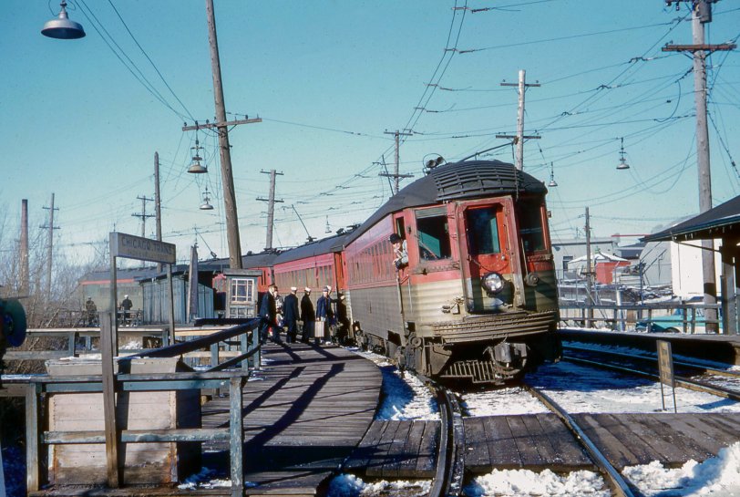 January 16, 1960. It was about 1 o'clock on a cool, crisp, sunny Saturday afternoon at the Lake Bluff stop of the Chicago, North Shore and Milwaukee interurban railroad. The North Shore was one of America's very last operating interurbans when I photographed a group of cadets from the nearby Great Lakes Naval Training Center climbing aboard a southbound train for a weekend of fun and relaxation in downtown Chicago. The  attentive motorman is keeping an eye on the conductor for the two-bell start signal while at the same time observing what I was doing with my camera.  The once busy line was abandoned three years later, almost to the day. 35mm Kodachrome by William D. Volkmer. View full size.
