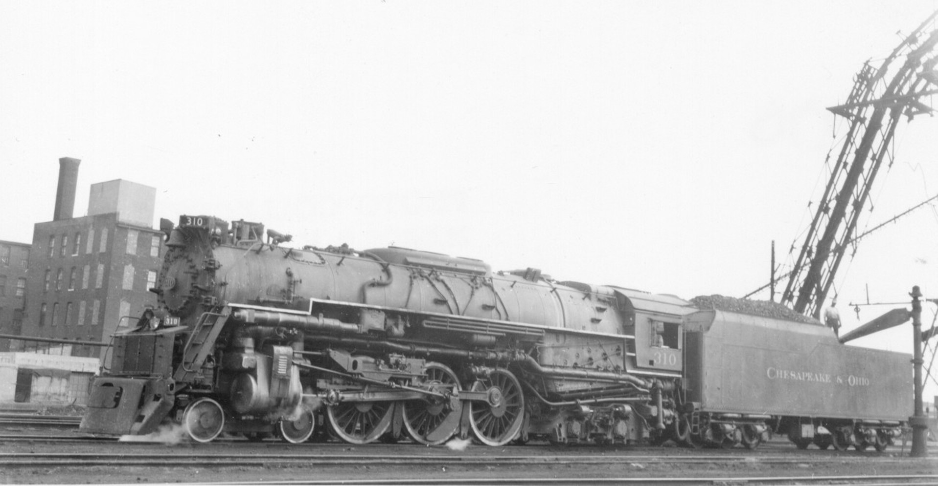 C&O 310, class L2a 4-6-4 Hudson type on ready track at Cincinnati Union Terminal service area, September 1950. Built by Baldwin in 1948, the L2a's were the world's largest Hudson types, dwarfing those of the New York Central and weighing in slightly heavier than those of AT&SF. They featured Franklin type B rotary cam poppet valves and 78" drivers. All were assigned to mainline passenger work on C&O's flatter western main lines, working between Cincinnati/Detroit and Hinton, WV. E-8 diesels bumped the Hudsons from passenger service in 1952 and all were out of service the following year. All were scrapped by 1955. View full size.