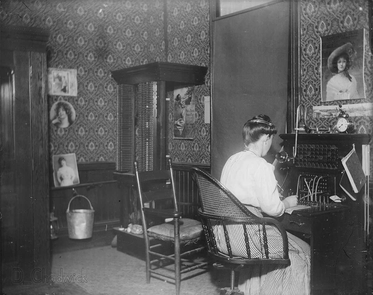 Central New York State.  Does anybody know if this would have been the telephone system for a hotel or possibly for an entire small town?  The poster with the girl standing on a swing is for the New York State Fair but there’s no year on it.   Scanned from the original 5x4 inch glass negative. View full size.